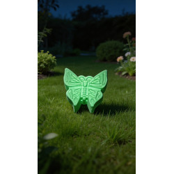 Mariposa artesanal fosforescente de cemento , brillando en color verde en la oscuridad