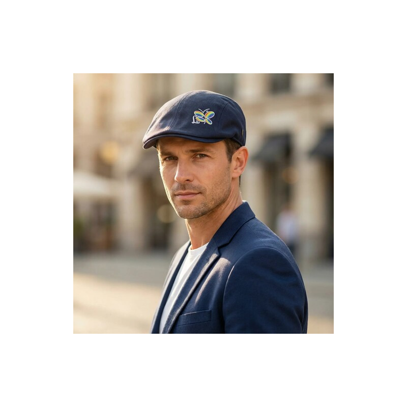 Persona luciendo una boina azul marino con detalle de libélula arcoíris en un conjunto casual