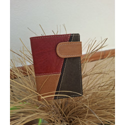 Cartera de piel elegante y compacta hecha a mano en Ubrique, de lisviv, sobre un jarrón de esparto