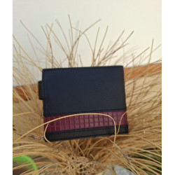 Cartera de cuero legitimo de Ubrique con sello de autenticidad de lisviv, apoyada en un jarrón de esparto