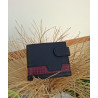 Cartera artesanal hecha en Ubrique con piel de máxima calidad, diseño lisviv, parte trasera sobre jarrón de esparto