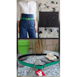 Cinturón de piel verde vivo lisviv con hebilla plateada ovalada, puesto en pantalón azul de talle alto. Hecho en España.