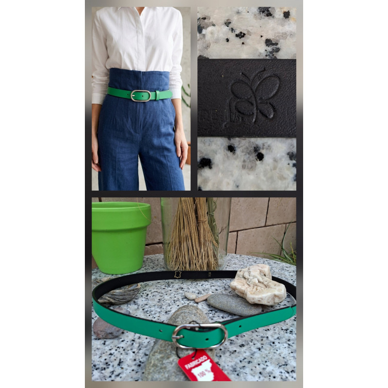 Cinturón de piel verde vivo lisviv con hebilla plateada ovalada, puesto en pantalón azul de talle alto. Hecho en España.