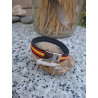 Pulsera de piel negra con bandera de España y cierre metálico.