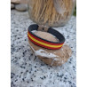 Lateral de pulsera de piel negra con cinta bandera de España.