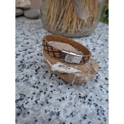 Detalle de cierre de acero inoxidable en pulsera de piel marrón.