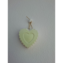 Adorno de corazón en cemento blanco fosforescente colgado en la pared con cordón rústico