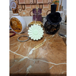 Figura artesanal de margarita en cemento blanco de día colocada sobre una mesa de mármol.
