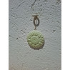 Adorno en forma de girasol de cemento blanco para colgar en la pared con cordón fino.