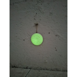 Efecto brillante verde nocturno de la figura de girasol fosforescente colgada en la pared.
