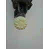 Adorno de flor de caléndula en cemento blanco colgado de un farol de pared de día.