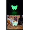 Montaje de día y de noche de la figura de mariposa artesanal con brillo verde fosforescente.