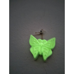 Efecto de brillo verde fosforescente de la mariposa decorativa colgada en la pared a oscuras.