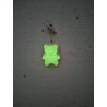 Efecto de brillo verde nocturno del osito de peluche pequeño fosforescente colgado en la pared.