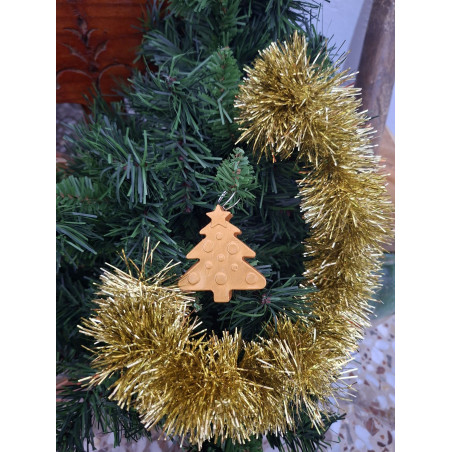 Adorno colgante de árbol de Navidad en cemento pintado a mano de color oro brillante colocado en un abeto.