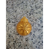 Detalle en primer plano del relieve de copo de nieve en la bola de Navidad de cemento color oro.