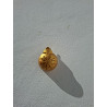 Esfera navideña de cemento pintada en oro con relieve de copo de nieve colgada en la pared de día.