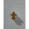 Muñeco de galleta navideña de cemento pintado en color oro colgado en la pared con cordón rústico.