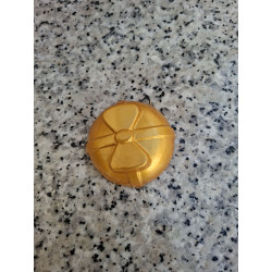 Detalle en primer plano de la forma esférica y relieve de lazo de la bola de Navidad de cemento color oro.
