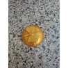 Detalle en primer plano de la forma esférica y relieve de lazo de la bola de Navidad de cemento color oro.