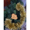 Adorno navideño con silueta de trineo cargado de regalos en cemento color oro colgado en el abeto.