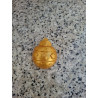 Detalle en primer plano de la cenefa de estrellas y líneas de puntos grabadas en la bola de Navidad de cemento oro.