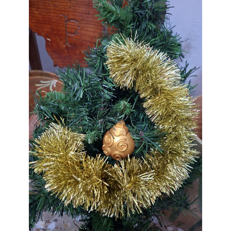 Adorno navideño de bola de cemento pintada en color oro con relieve de líneas en espiral y volutas colgada en abeto.