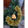 Adorno navideño con silueta de gorro de Papa Noel en cemento color oro colgado en el abeto festivo.
