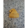 Detalle en primer plano del relieve del pompón y el dobladillo en la figura de gorro navideño de cemento oro.