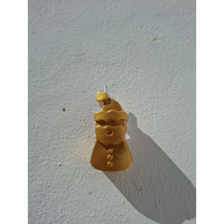 Figura alargada de Papá Noel de cemento pintada en color oro colgada en la pared con cordón rústico.