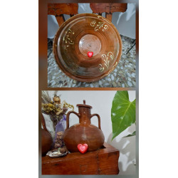 Adorno de corazón de cemento pintado a mano colocado en lebrillo tradicional de barro y vasija rústica.