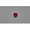 Adorno de corazón de cemento pintado a mano con relieve doble colgado en una pared texturizada blanca.