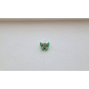 Adorno de mariposa de cemento verde pintado a mano colgado de forma individual en una pared blanca exterior.