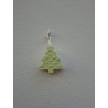 Adorno de árbol de navidad de cemento fosforescente con relieve de bolas colgado de forma vertical en una pared blanca exterior.