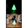 Adorno de árbol de Navidad de cemento fosforescente escalonado mostrando su brillo verde y su silueta de día sobre mármol.