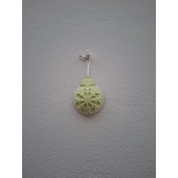 Adorno de bola de Navidad de cemento fosforescente con relieve de copo de nieve colgado de forma vertical en pared exterior.