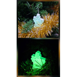 Adorno campanas de Navidad de cemento fosforescente con relieve de lazo de día en el abeto y brillando en color verde de noche.