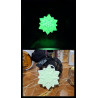 Adorno estrella copo de nieve de cemento fosforescente mostrando su brillo verde y su diseño de día sobre mármol.