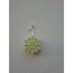 Adorno de estrella copo de nieve de cemento fosforescente con relieve geométrico colgado de forma vertical en pared exterior.