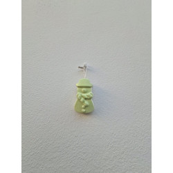 Adorno de muñeco de nieve de cemento fosforescente modelo bombín colgado de forma vertical en una pared blanca exterior.
