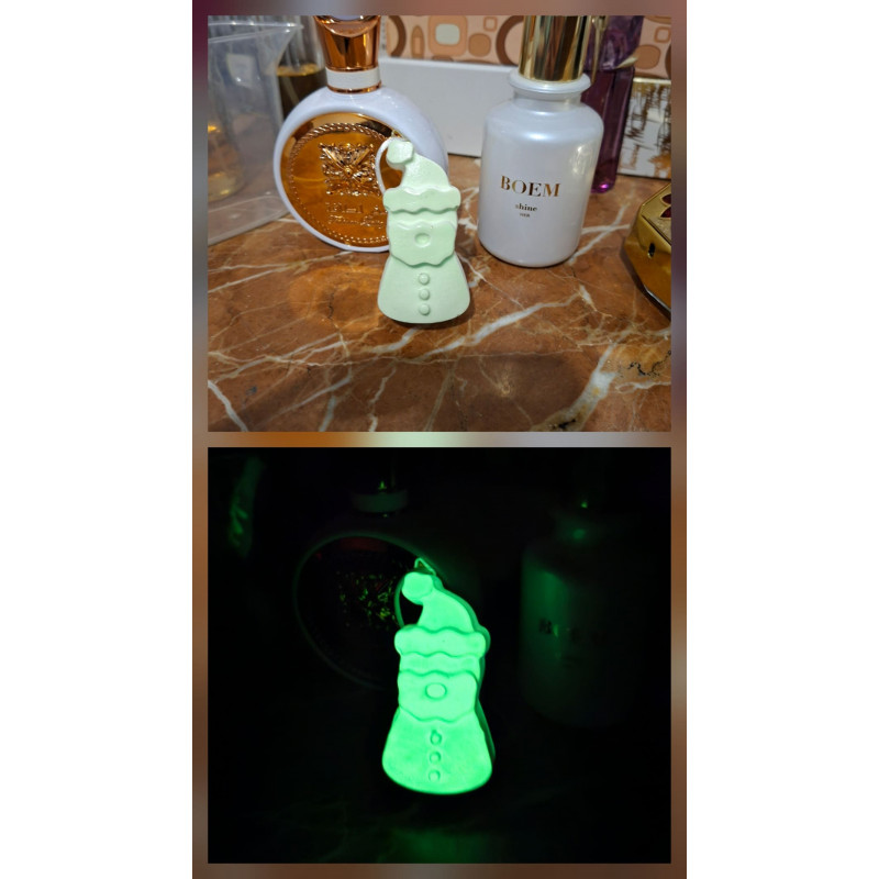 Adorno Papá Noel de cemento fosforescente con gorro inclinado mostrando su diseño de día y su brillo verde en la oscuridad.