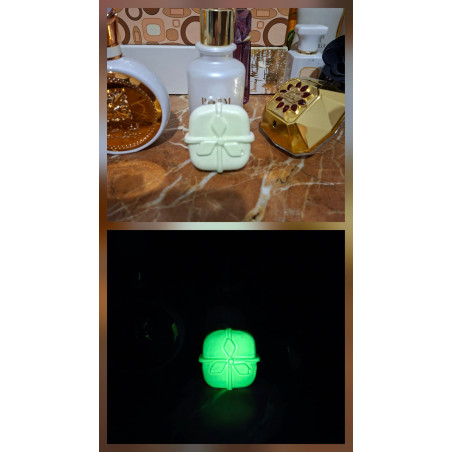 Adorno regalo de Navidad de cemento fosforescente mostrando su diseño con lazo de día y su brillo verde en la oscuridad.