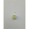 Adorno regalo de Navidad de cemento fosforescente con relieve de lazo colgado de forma vertical en una pared blanca exterior.