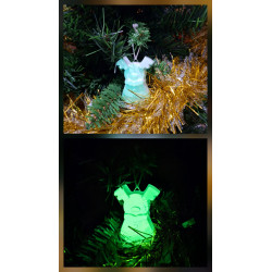 Adorno reno navideño de cuerpo entero de cemento fosforescente de día en el abeto y brillando verde de noche.