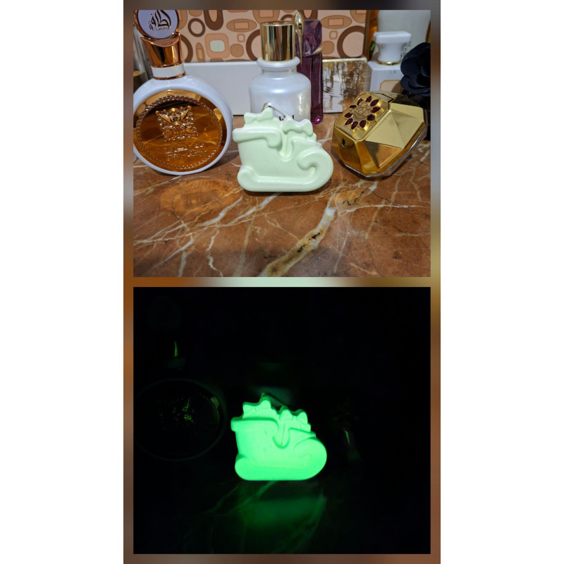 Adorno trineo Navidad de cemento fosforescente mostrando su diseño con regalos de día y su brillo verde en la oscuridad.