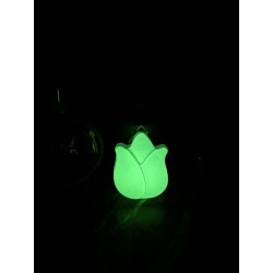 Adorno de tulipán de cemento fosforescente mostrando su silueta floral y su intenso brillo verde en la oscuridad.
