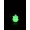 Adorno de tulipán de cemento fosforescente mostrando su silueta floral y su intenso brillo verde en la oscuridad.