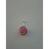 Adorno de rosa de cemento pintada a mano en color rosa colgado de forma vertical en una pared blanca exterior.