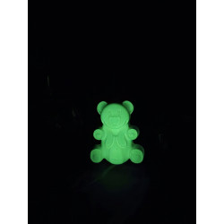 Adorno osito de cemento fosforescente estilo gominola mostrando su silueta infantil y su intenso brillo verde en la oscuridad.