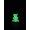 Adorno osito de cemento fosforescente estilo gominola mostrando su silueta infantil y su intenso brillo verde en la oscuridad.